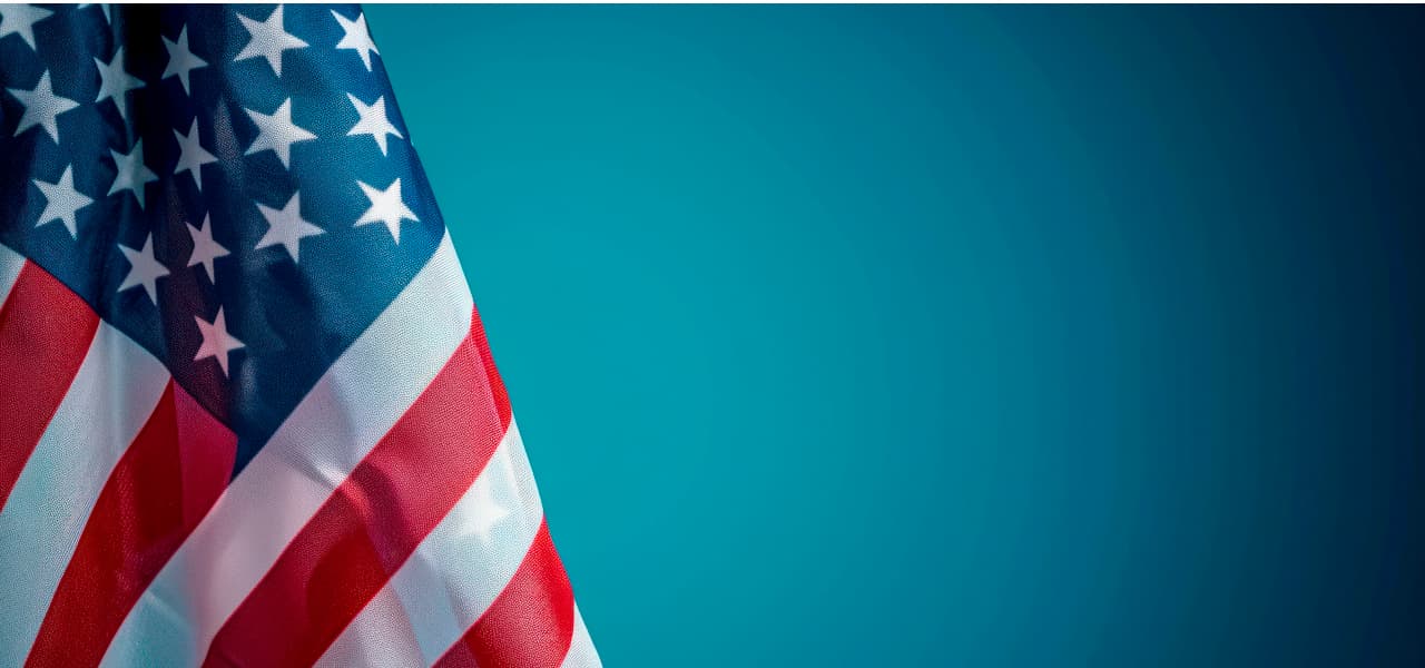 Amerikanische Flagge vor blauem Hintergrund. | Motiv ©Hunman - stock.adobe.com | © stock.adobe.com, September 2024