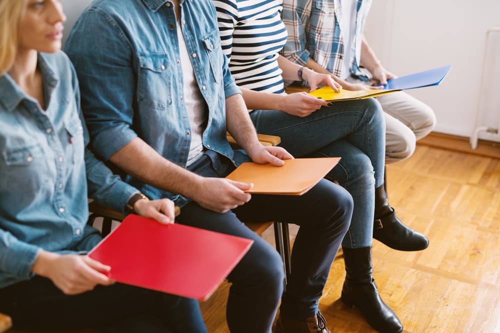 Ausschnitt von Personen, die mit Mappe in der Hand in einem Wartezimmer sitzen. | Motiv ©dusanpetkovic1  - stock.adobe.com | © stock.adobe.com, September 2019