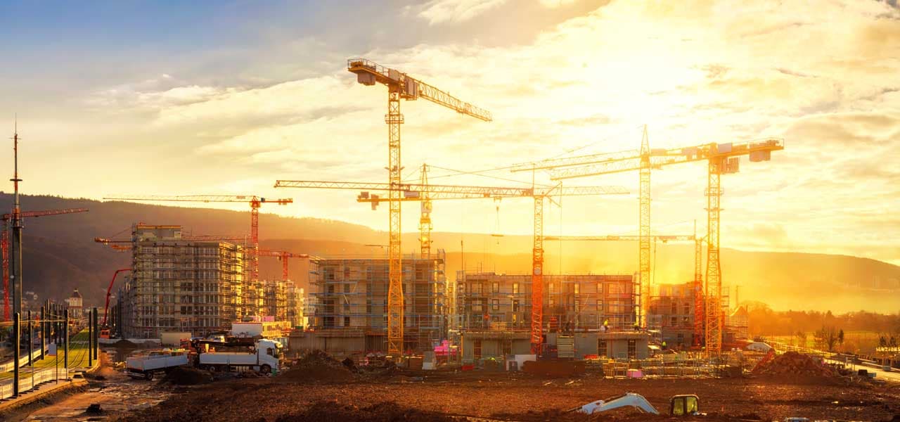 Baukräne mit unfertigen Häusern im Sonnenuntergang | Motiv ©Smileus - stock.adobe.com | © stock.adobe.com, September 2020