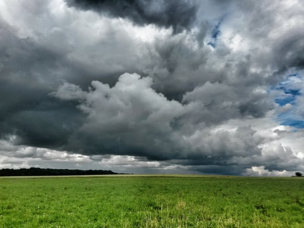 Düstere Gewitterwolken hängen über einem grünen Feld | Motiv ©shocky-stock.adobe.com | © stock.adobe.com, Oktober 2022