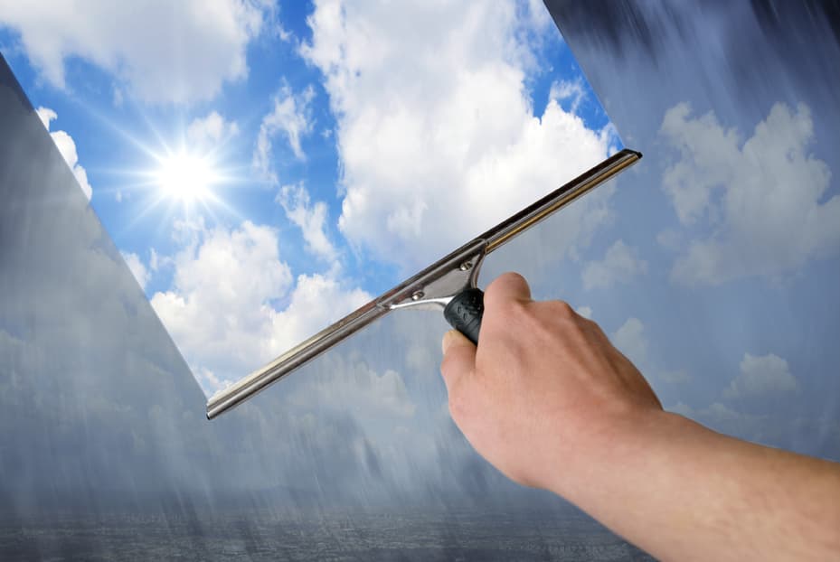 Positiv | Motiv © Gunnar Assmy - Fotolia.com | © Fotolia.com, März 2014 Hand hält Fensterabzieher, durch das Fenster kann man einen blauen Himmel mit Wolken und Sonnenschein sehen | Motiv © Gunnar Assmy - Fotolia.com | © Fotolia.com, März 2014